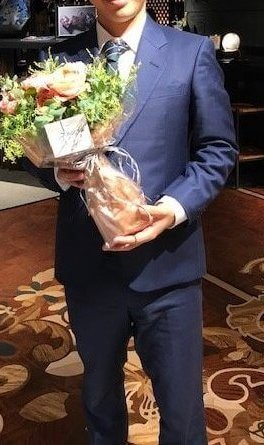 花を持つスーツ男性